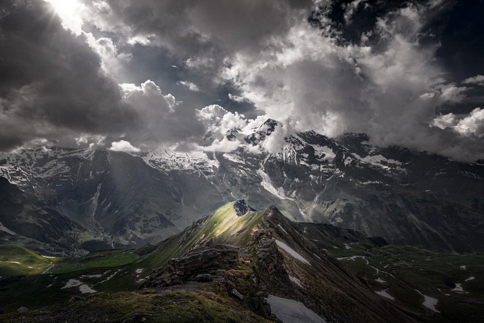 Sunlight breaking through clouds over Austrian mountains