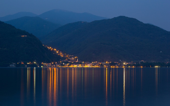 Town lights reflecting on a lake at dusk