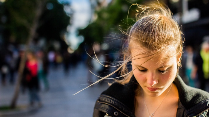 A young woman with blonde hair looking down