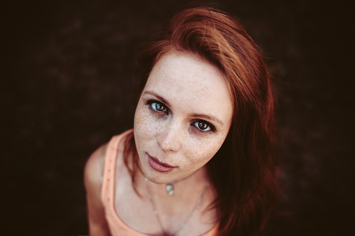Portrait of a young woman with freckles and red hair