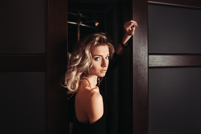 Blonde woman with blue eyes posing indoors