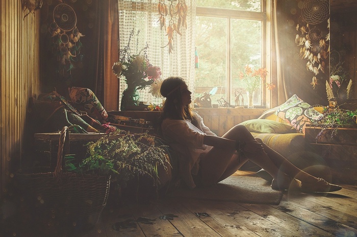Woman with long brunette hair sitting by a window