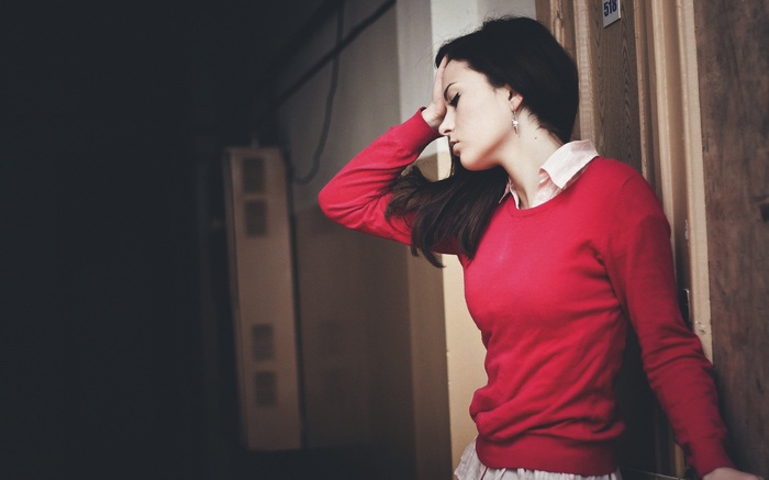 Woman with long dark hair holding her head