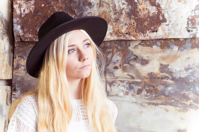 Woman with blonde hair wearing a black hat