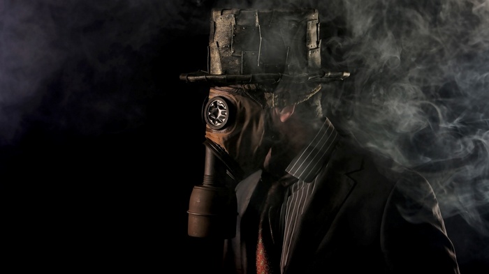 Man in steampunk hat and gas mask with smoke
