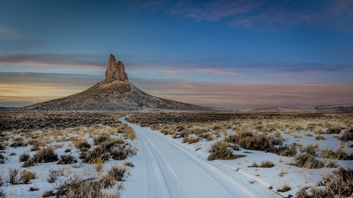 Snowy dirt road leading to Shiprock in New Mexico, USA
