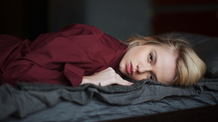 Woman with blonde hair lying in bed