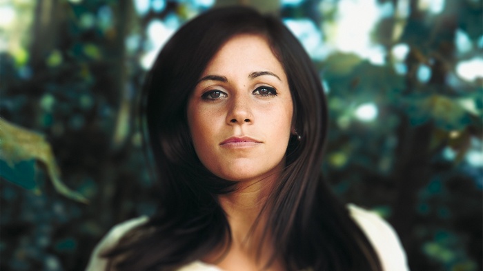 Woman with dark hair looking at the camera