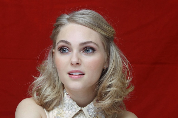 AnnaSophia Robb posing against a red background