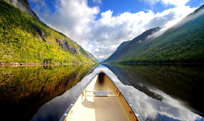 Canoe on a calm lake between mountains