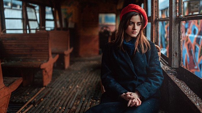 Woman in red hat inside abandoned train car