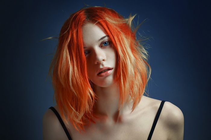 Woman with orange and blonde dyed hair and blue eyes