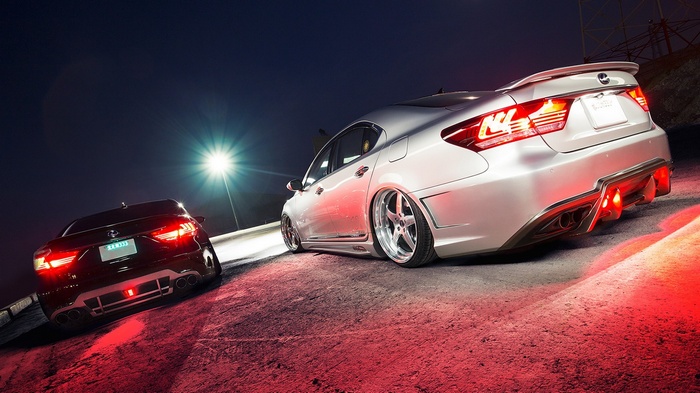 Two modified Lexus cars at night