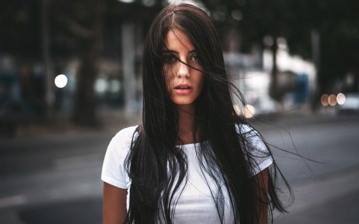 Brunette woman with long dark hair in a white t-shirt