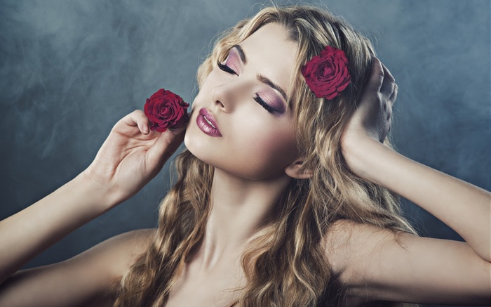 Woman with blonde wavy hair and red roses