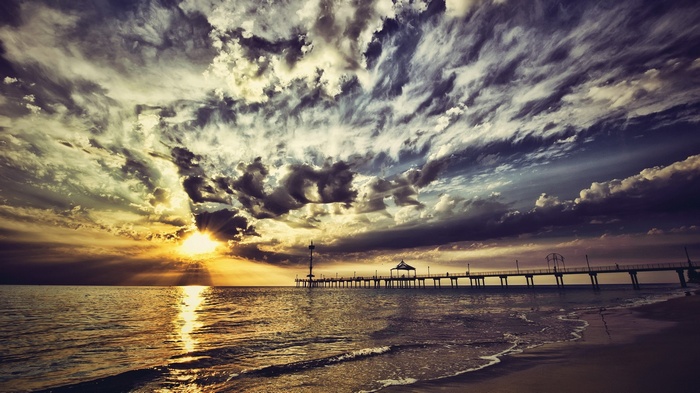 Sunset over the ocean with a pier