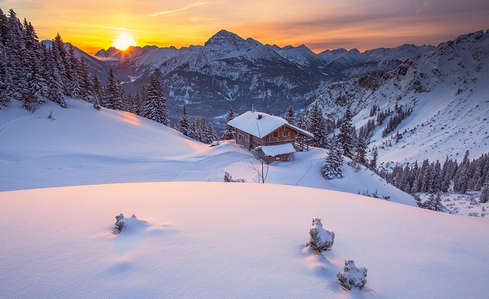 Wooden cabin in snowy mountains at sunset, Tyrol