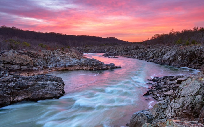 River flowing through rocky gorge at sunset