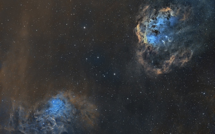 Two nebulae in deep space with stars