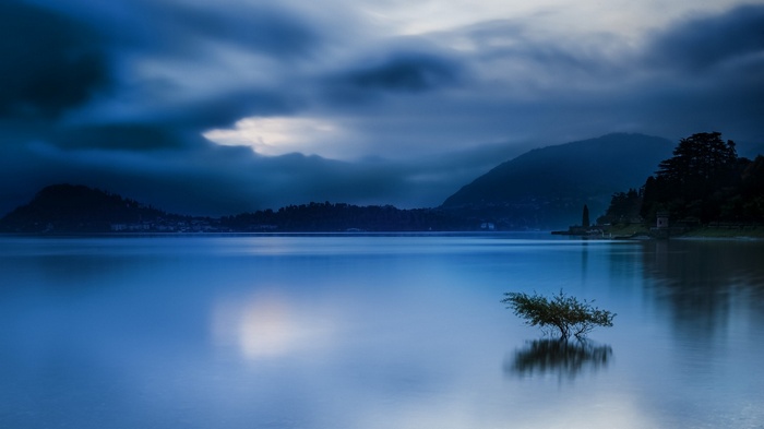 Calm lake with mountains and clouds in Italy