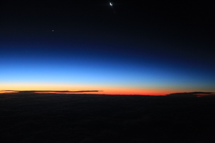 Crescent Moon and Stars Over Clouds at Twilight