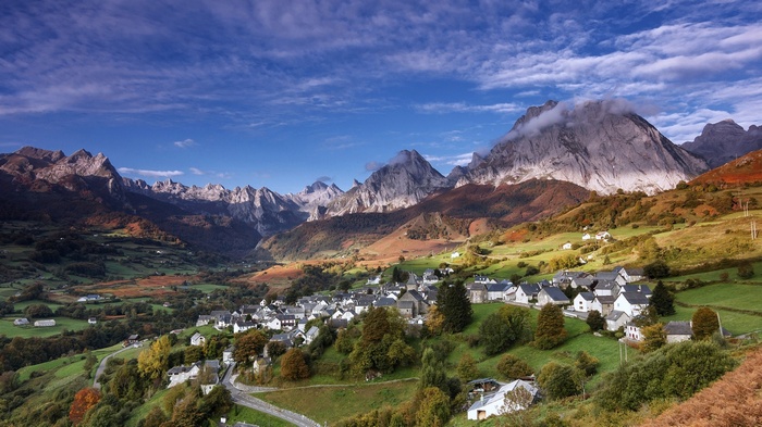 Village nestled in a mountain valley with autumn foliage