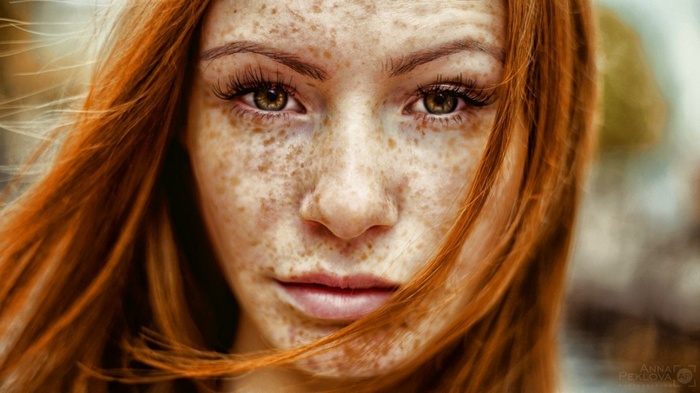 Redhead woman with freckles looking at viewer