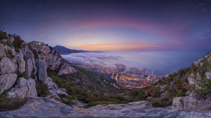 Monaco cityscape at dusk with clouds and mountains