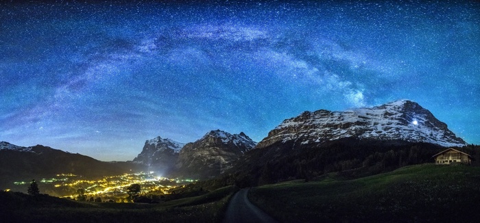 Milky Way over Swiss Alps village and snowy peaks