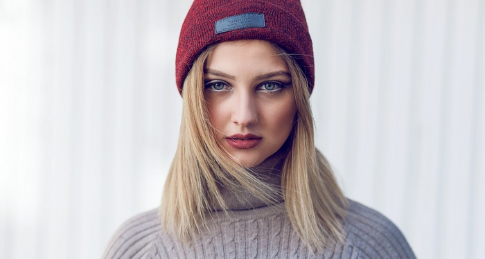 Portrait of a blonde woman wearing a red beanie