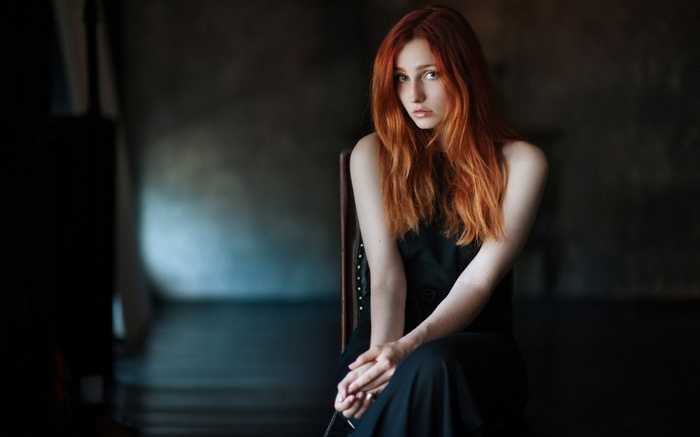Vladislava Masko in a black dress sitting on a chair