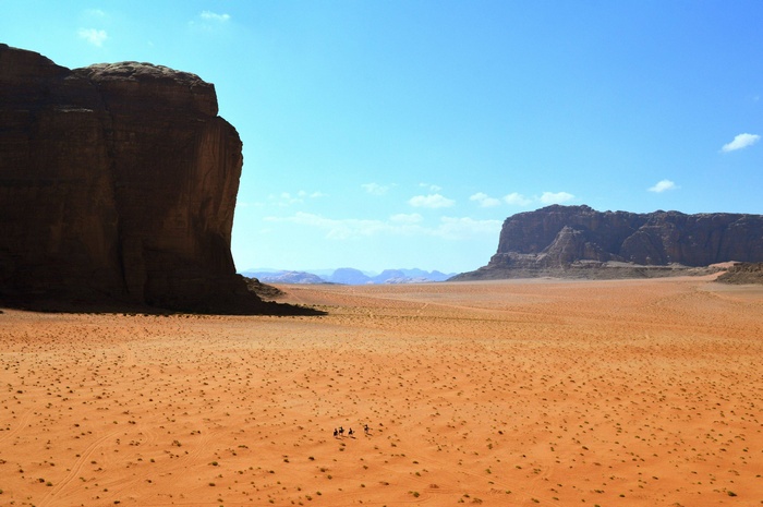 People riding camels in a desert landscape
