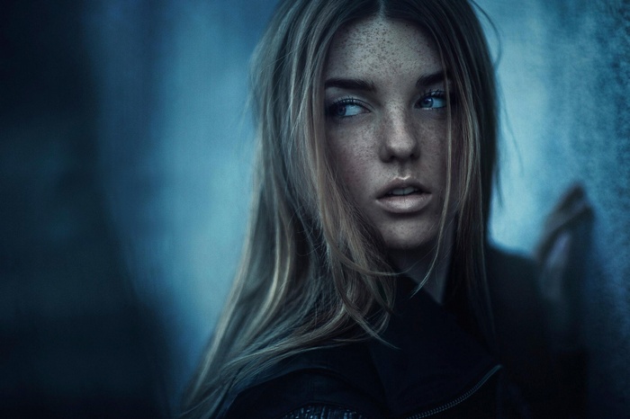 Woman with freckles and long hair looking away