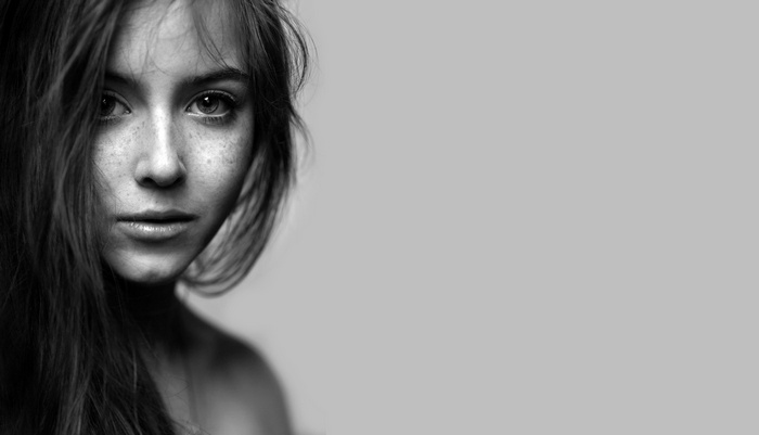 Monochrome portrait of a young woman with freckles