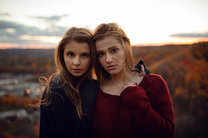 Two young women posing outdoors at sunset