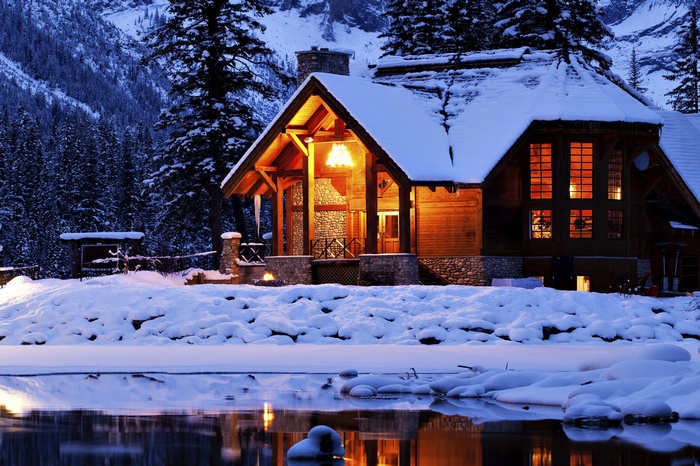 Wooden cabin by a frozen lake in winter