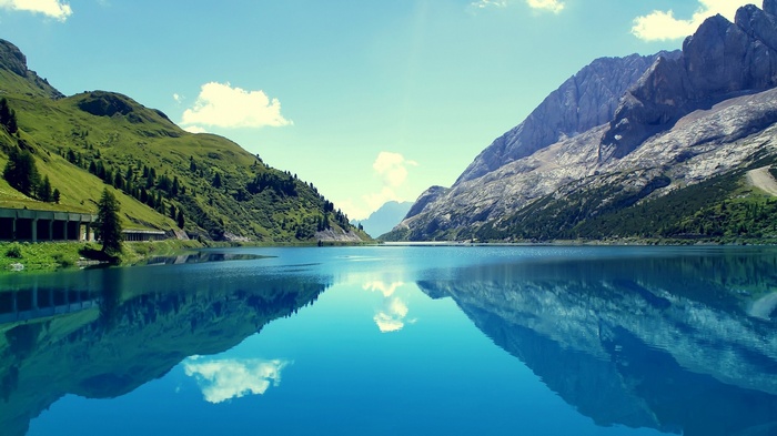 Calm lake reflecting mountains and sky