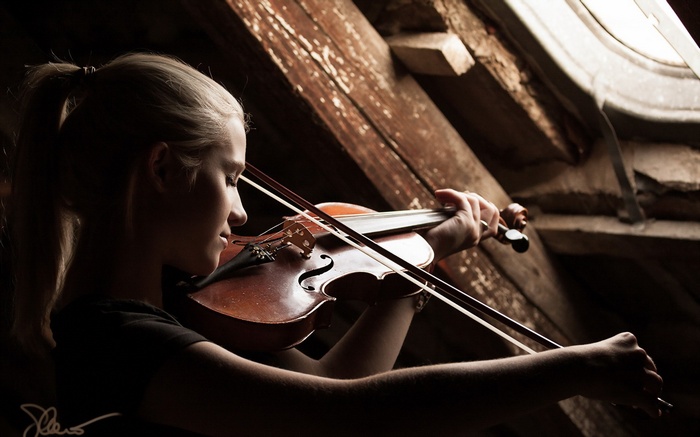 Girl playing violin near a window