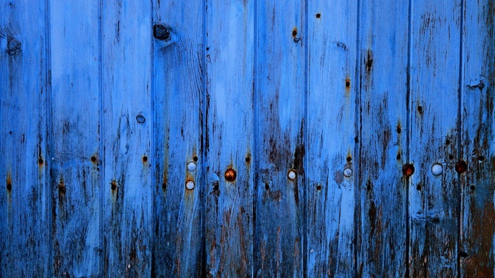 Blue weathered wooden planks with rust