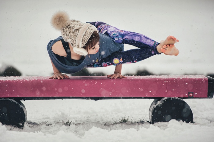 Woman performing yoga in the snow