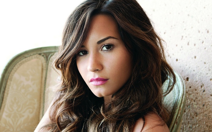 Demi Lovato with long brown hair looking at viewer