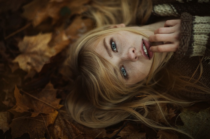 Woman lying on autumn leaves