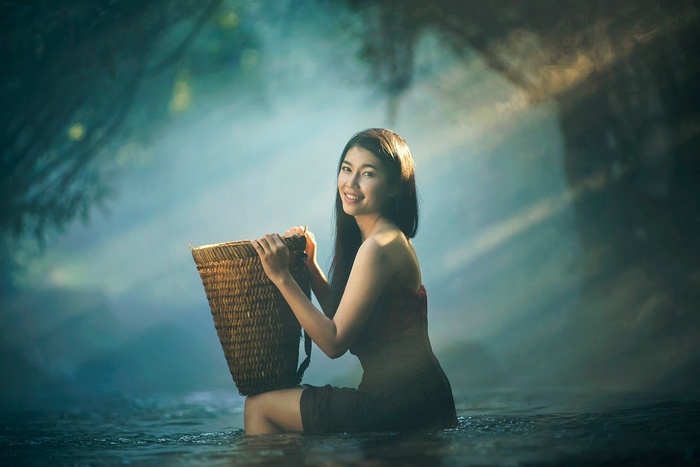 Asian woman with basket in water