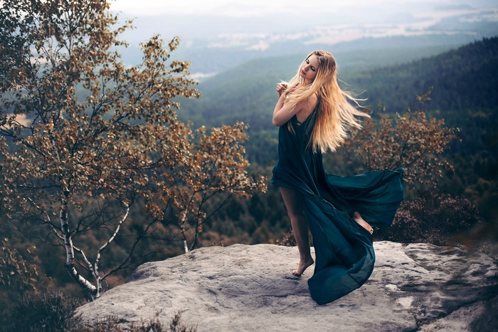 Woman in a flowing dress on a rocky outcrop