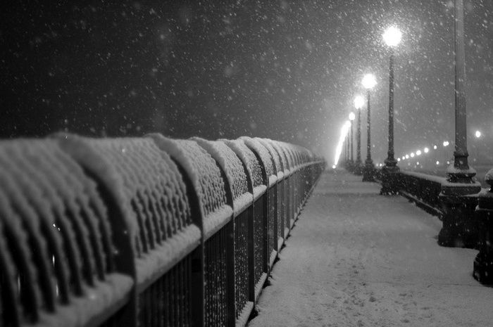 Snowy bridge with streetlights at night