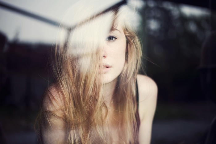 Woman with blonde hair looking through a window