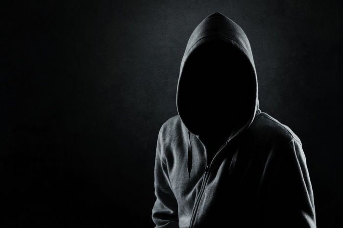 Person in a hooded sweater in the dark