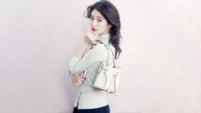 Suzy poses with a white bucket bag