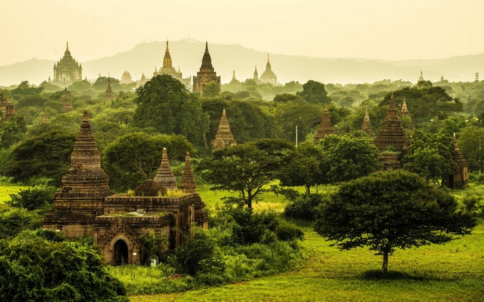 Ancient Buddhist temples in a misty green landscape in Myanmar