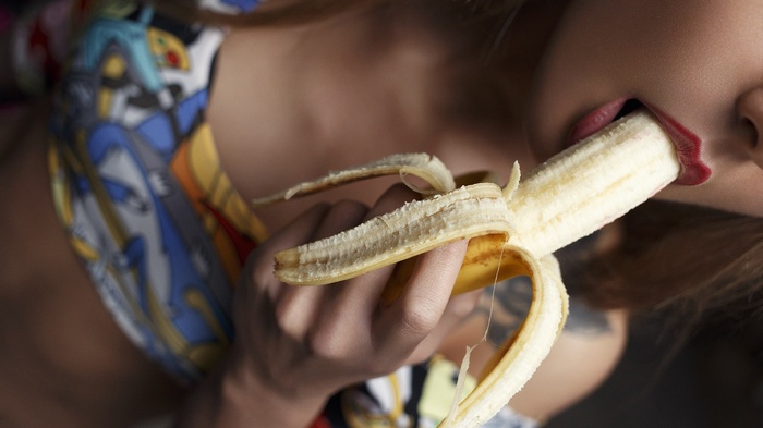 Woman eating a banana with red lipstick
